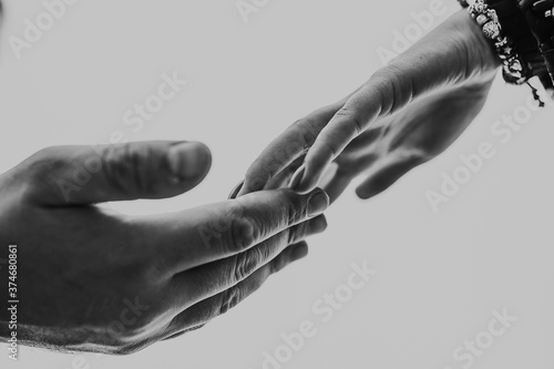 A gentle touch of the hands of a man and a woman on a white background. Love connection help concepts. Be hand in hand.