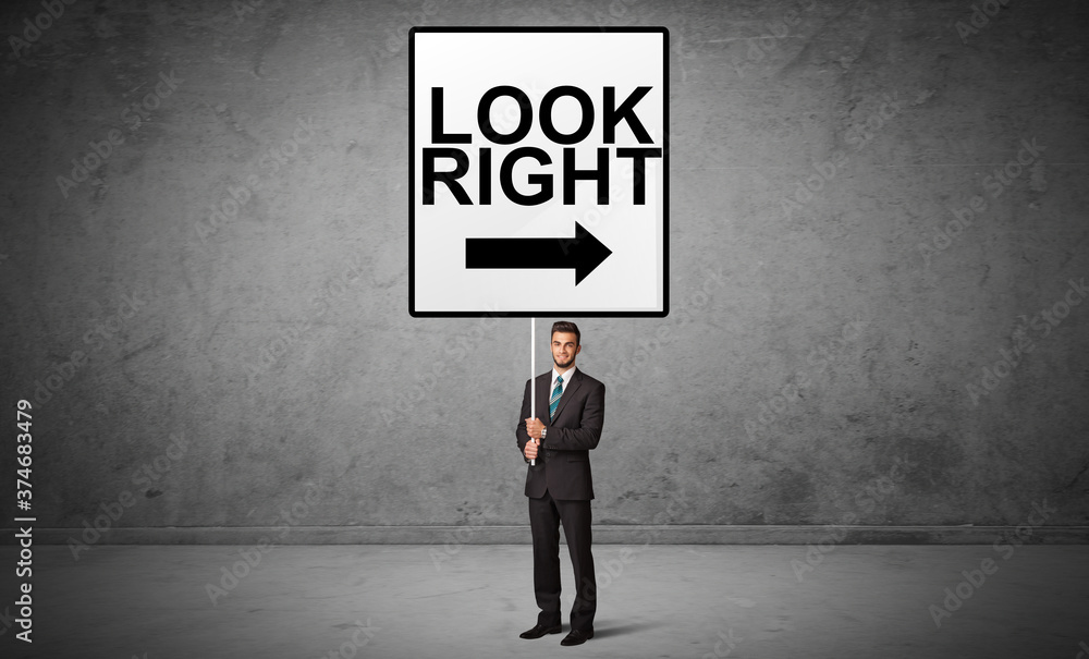 business person holding a traffic sign with LOOK RIGHT inscription, new idea concept business person holding a traffic sign with LOOK RIGHT inscription, new idea concept