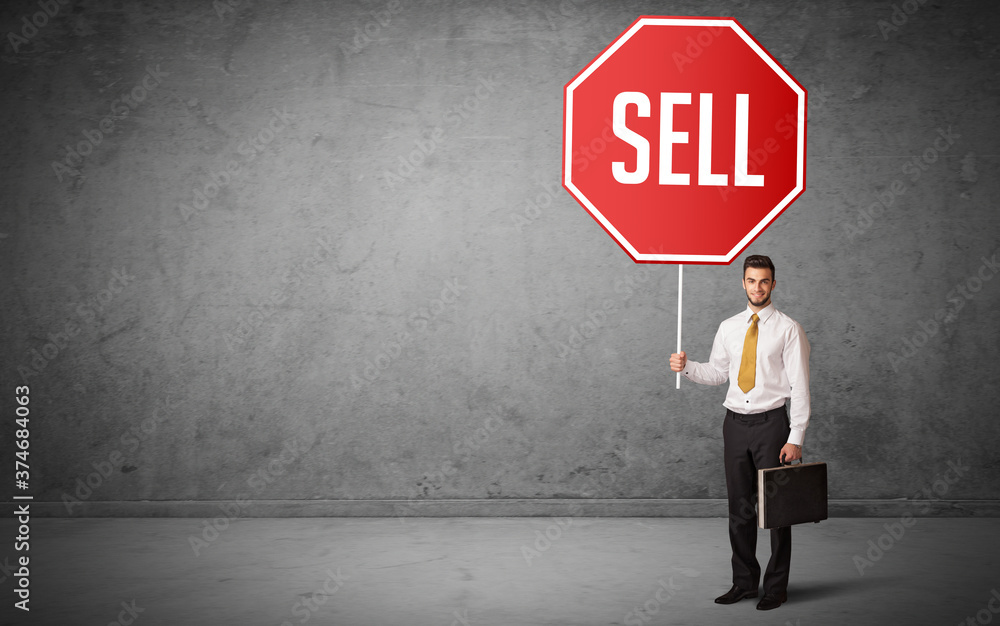 Young business person holding road sign with SELL inscription, new rules concept Young business person holding road sign with SELL inscription, new rules concept