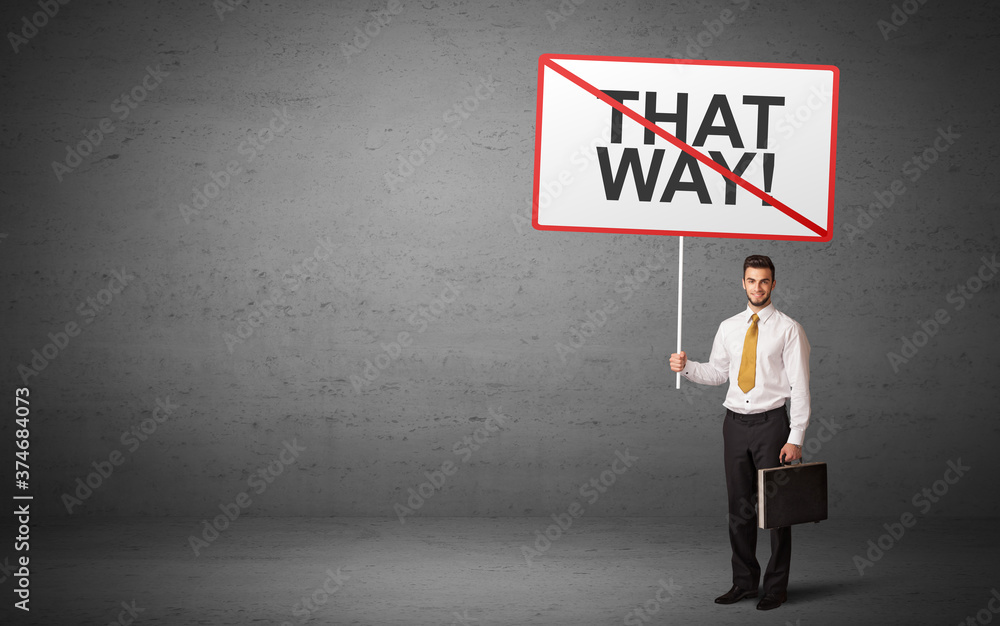 business person holding a traffic sign with THAT WAY! inscription, new idea concept business person holding a traffic sign with THAT WAY! inscription, new idea concept