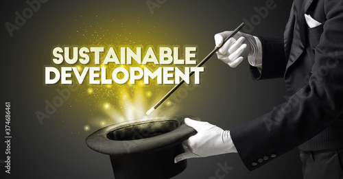 Illusionist is showing magic trick with SUSTAINABLE DEVELOPMENT inscription, new business model concept