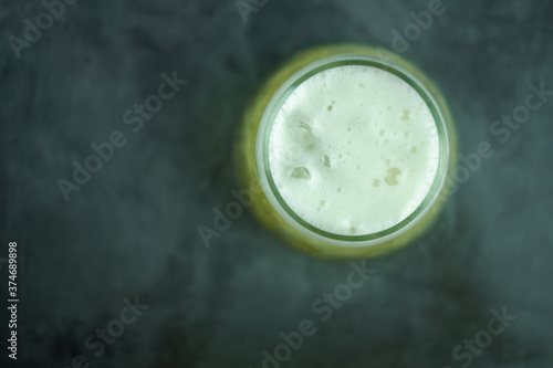 Beer glass with foam on a black background.