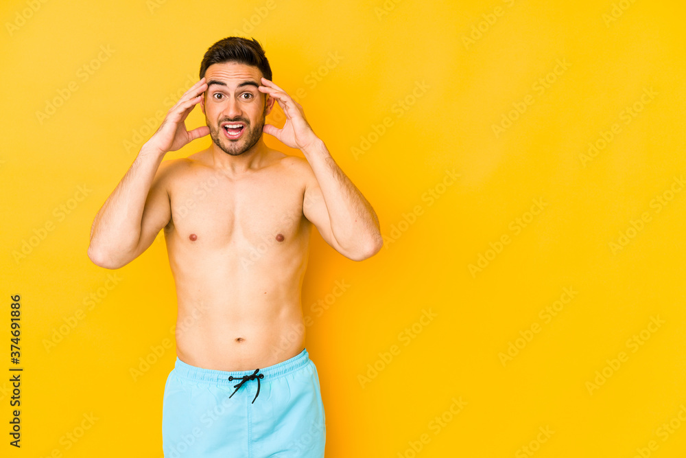 Young caucasian man with swimsuit isolated on yellow background Young caucasian man with trreceiving a pleasant surprise, excited and raising hands. Young caucasian man with swimsuit isolated on yellow background Young caucasian man with trreceiving a pleasant surprise, excited and raising hands.