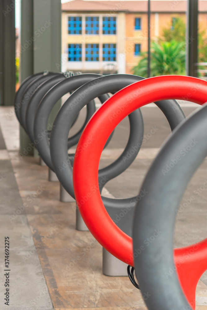 Bicycle parking area. Bright red ring in a row of grays