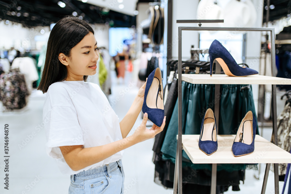 Pretty woman choosing shoes in clothing store Pretty woman choosing shoes in clothing store