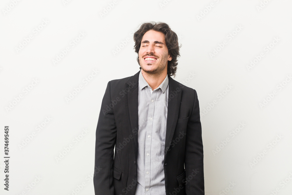 Young business man against a white background laughs and closes eyes, feels relaxed and happy. Young business man against a white background laughs and closes eyes, feels relaxed and happy.
