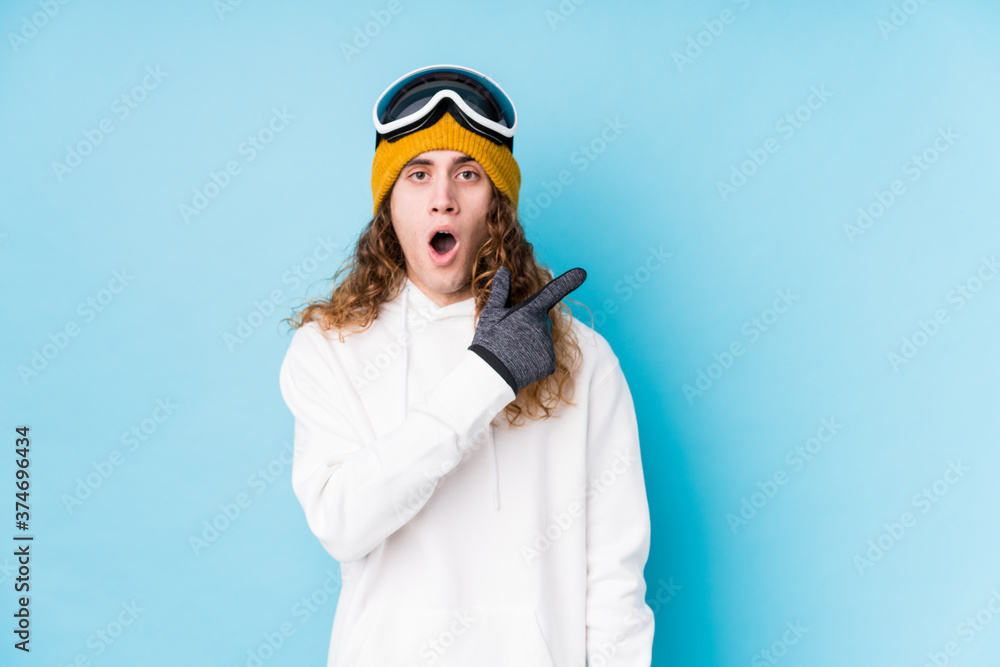 Young caucasian man wearing a ski clothes isolated pointing to the side Young caucasian man wearing a ski clothes isolated pointing to the side