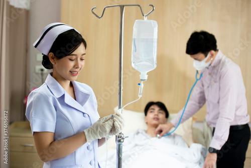 Portrait of asian nures puts the dropper in hospital room photo