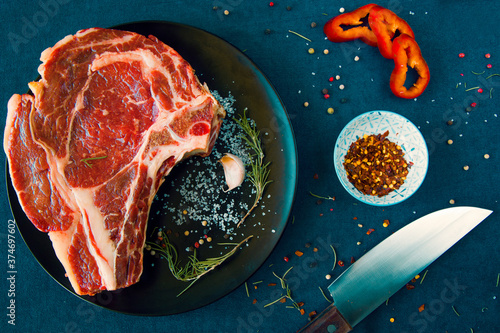 Raw beef meat on the table, spices and Rosemary, Rib eye steak ingredients. Pepper and coars salt. photo