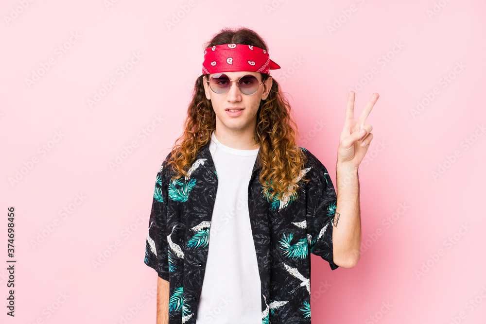 Young hippie caucasian man isolated showing victory sign and smiling broadly.