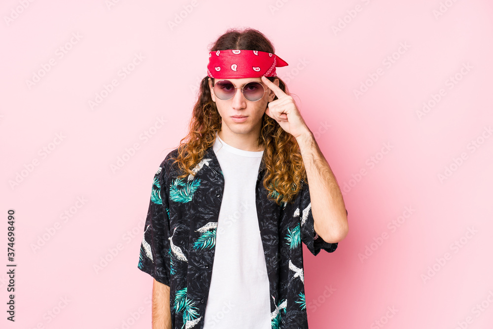 Young hippie caucasian man isolated pointing temple with finger, thinking, focused on a task.