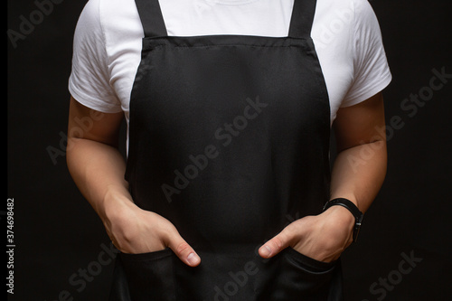 Canvas Print Black apron on a man closeup