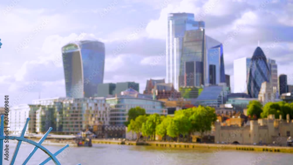 London city skyline and Tower of London, landscape view from Tower Bridge on a sunny summer day with blue sky and light clouds, blue fence London city skyline and Tower of London, landscape view from Tower Bridge on a sunny summer day with blue sky and light clouds, blue fence