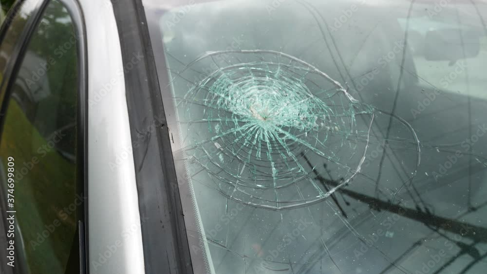 Stolen car, vandalized, and wrecked left abandoned in an empty, grassy