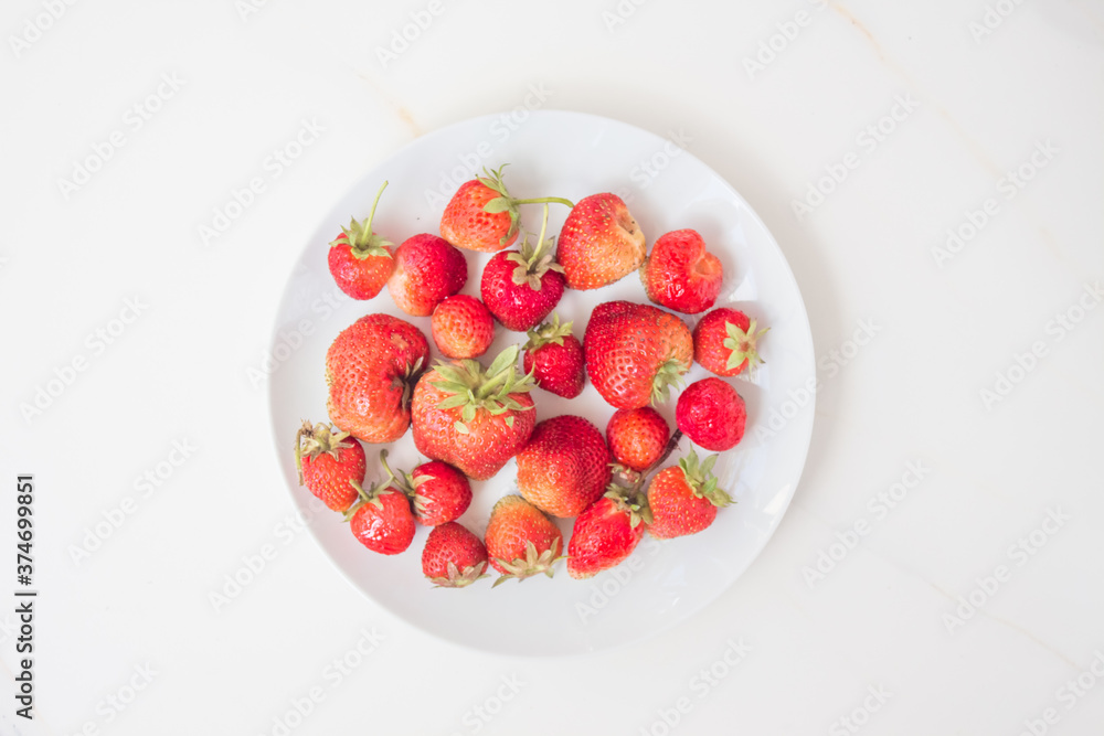 Appetizing strawberry from a home garden in a white terelka with copy space. Harvest season for strawberries and red berries. Allergy-free berry for raising immunity Appetizing strawberry from a home garden in a white terelka with copy space. Harvest season for strawberries and red berries. Allergy-free berry for raising immunity