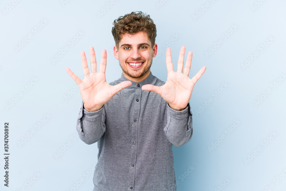 Naklejka premium Young blond curly hair caucasian man isolated showing number ten with hands.