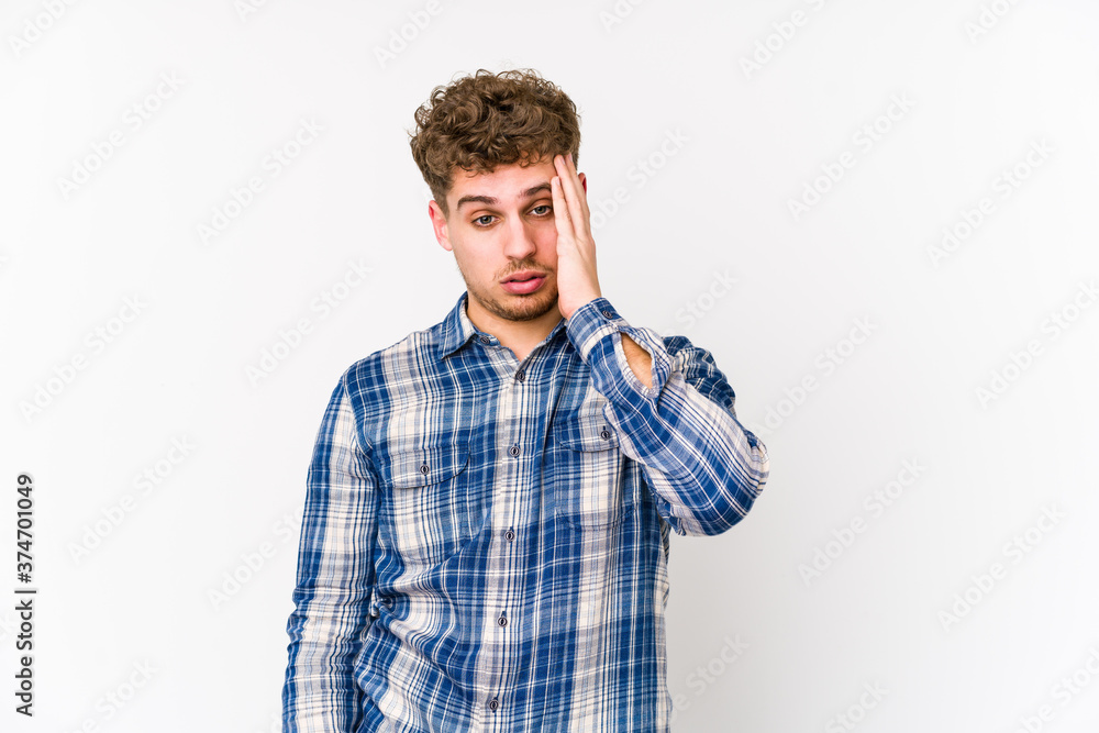 Young blond curly hair caucasian man isolated tired and very sleepy keeping hand on head. Young blond curly hair caucasian man isolated tired and very sleepy keeping hand on head.
