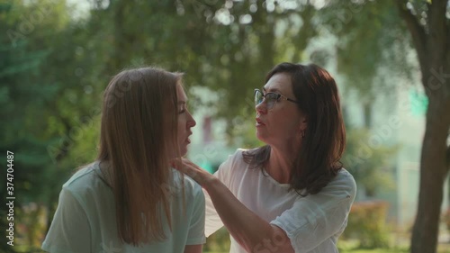 Smiling happy caucasian senior mother with her adult daughter hugging and laughing In Park. Concept of Age Inclusivity. photo