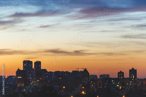 Close up picture of silhouette of the city with orange sky in sunset time. Kyiv view with small houses on the horizon with amazing sky and clouds. Panorama of Kyiv city silhouette. Ukraine.