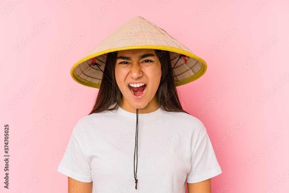 Young asian woman wearing a vietnamese hat isolated Young asian woman wearing a vietnamin hatscreaming very angry and aggressive. Young asian woman wearing a vietnamese hat isolated Young asian woman wearing a vietnamin hatscreaming very angry and aggressive.