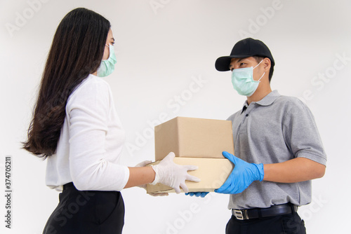 Delivery man bring parcel to customer by wearing surgical mask and gloves © lmanju