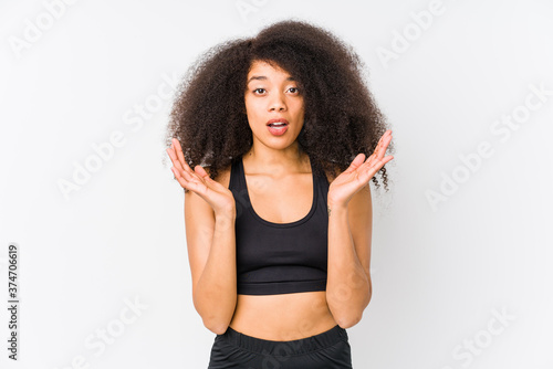 Young african american sporty woman surprised and shocked.