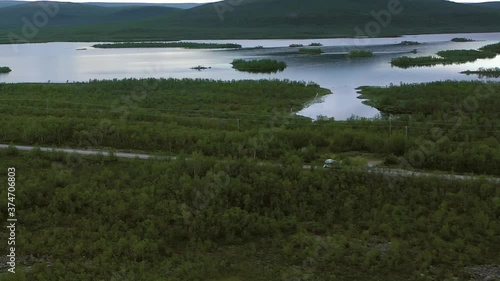 Aerial view following a Camper driving in boreal nature, on a gloomy, summer day, in Kasivarsi wilderness area, Enontekio, Lapland, Finland - Tracking, drone shot photo