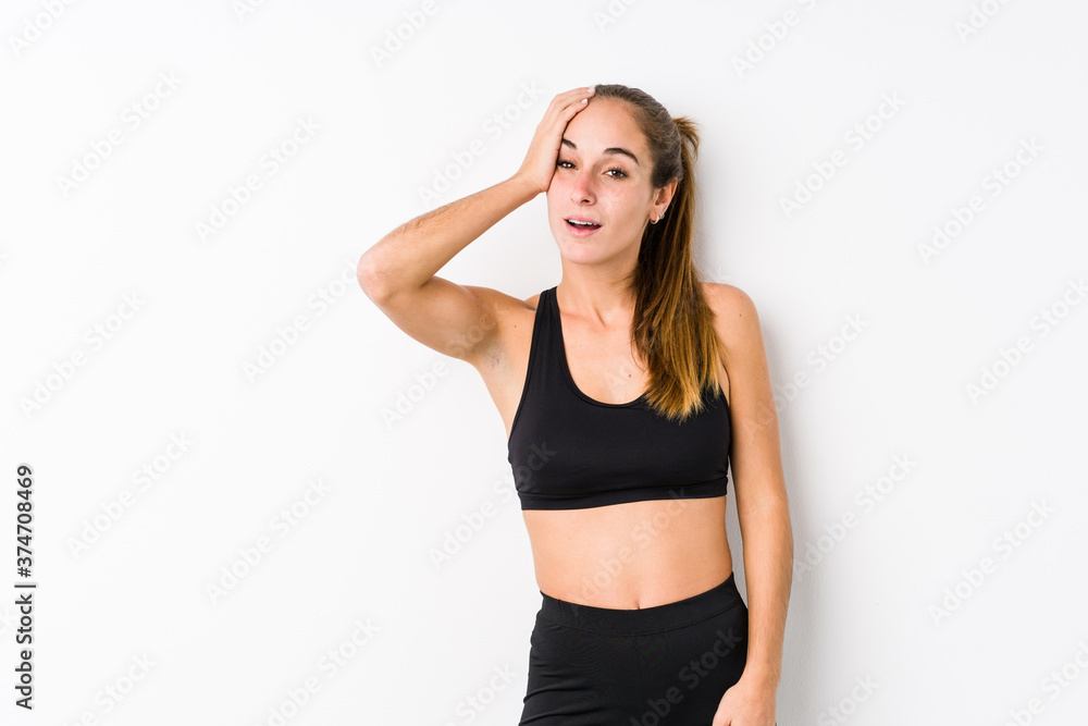 Young caucasian fitness woman posing in a white background tired and very sleepy keeping hand on head. Young caucasian fitness woman posing in a white background tired and very sleepy keeping hand on head.