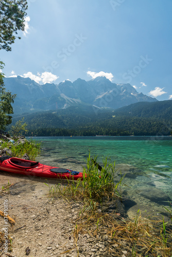 A red kayak at the Eibsee in front of the Zugspitze mountain