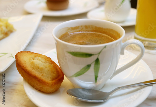 Cup of Hot Coffee with a Financier French Almond Mini Cake Served on the Tea Table