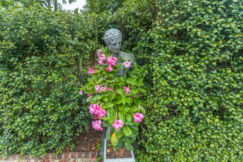 statute with pink flower vines
