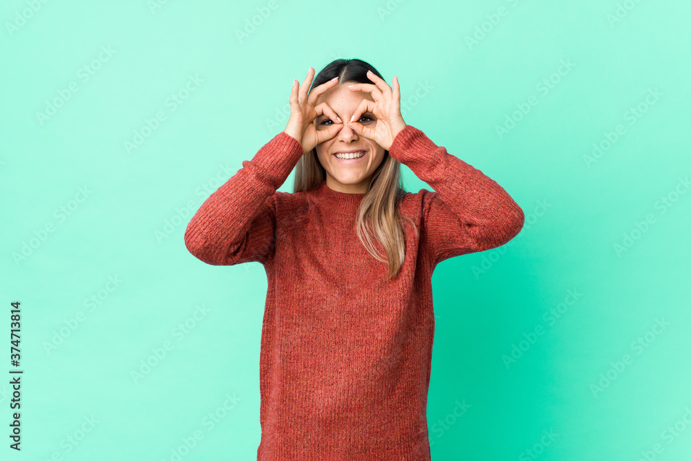 Naklejka premium Young caucasian woman isolated showing okay sign over eyes