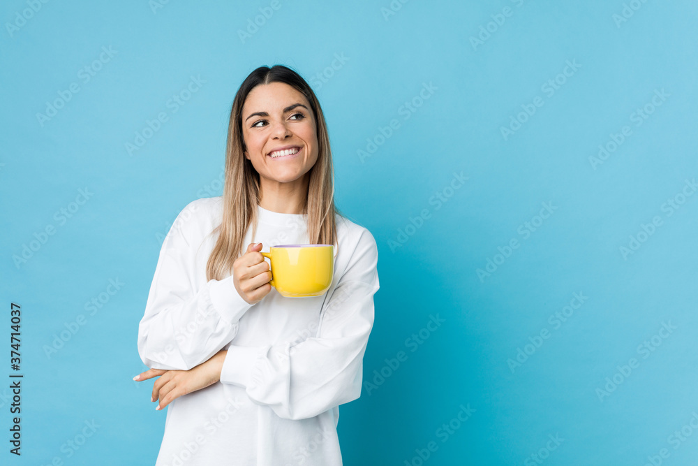Young caucasian woman holding a coffee cup smiling confident with crossed arms. Young caucasian woman holding a coffee cup smiling confident with crossed arms.