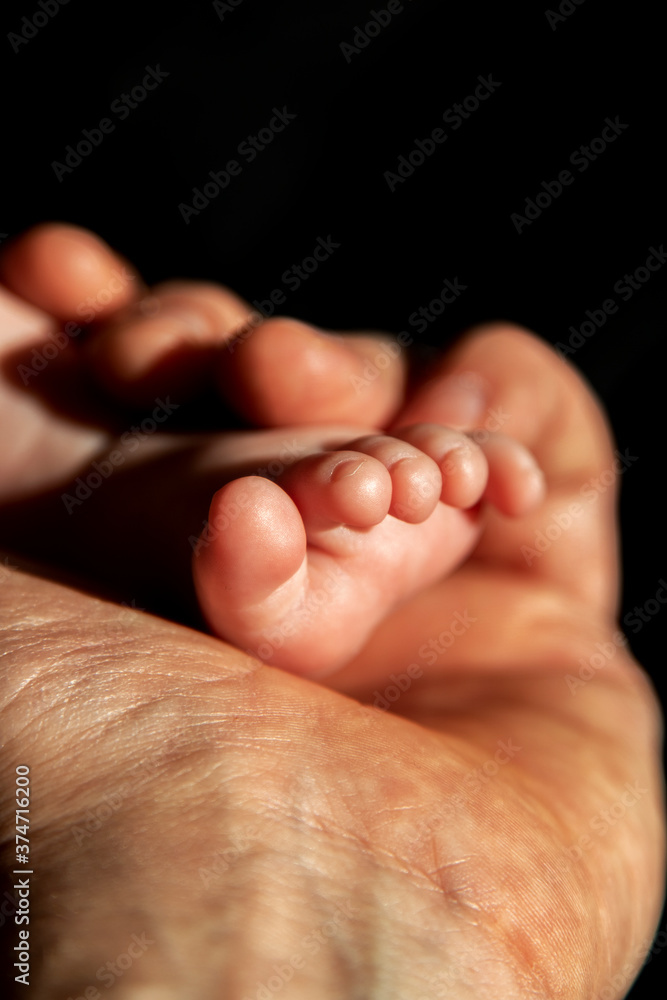 Father hand holding a baby foot