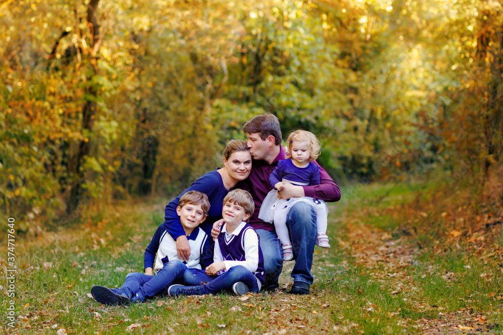 Portrait of young parents with three children. Mother, father, two kids brothers boys and little cute toddler sister girl having fun together in autumn forest. Happy family of five Portrait of young parents with three children. Mother, father, two kids brothers boys and little cute toddler sister girl having fun together in autumn forest. Happy family of five