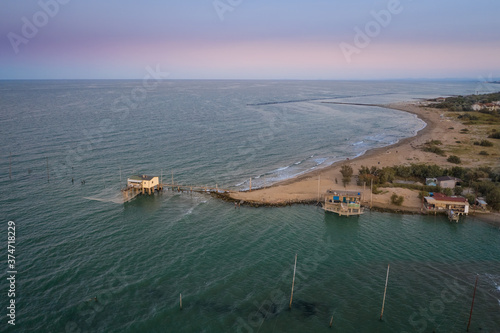 Landscapes shot of the valleys near Ravenna (Fiumi Uniti) where the river flows into the sea with the typical fishermen's huts at sunset