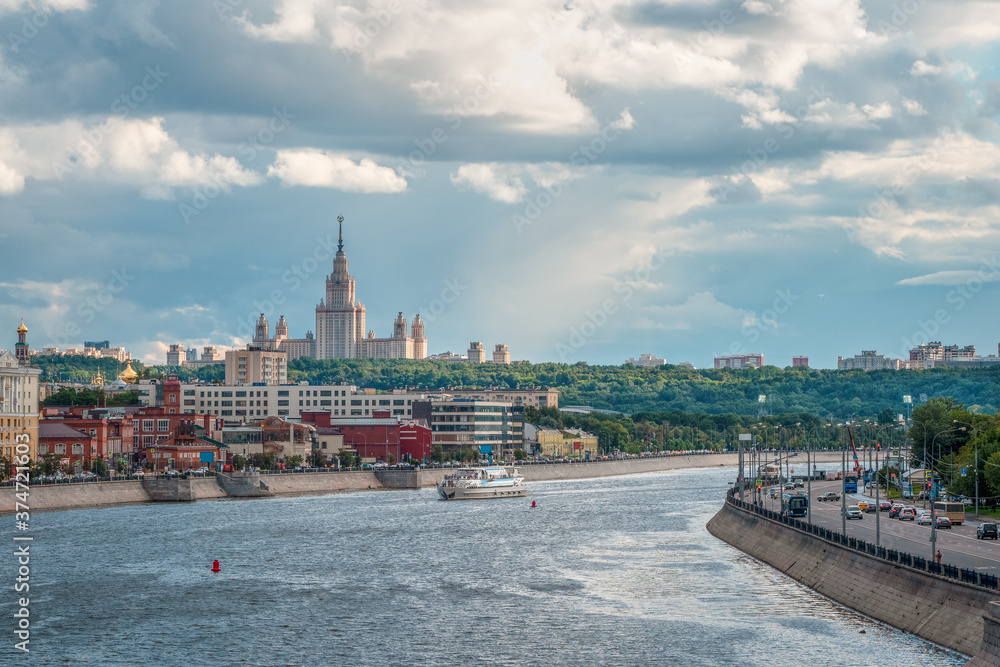 Fototapeta premium Beautiful Moscow evening cityscape. University on a green hill in the evening sun