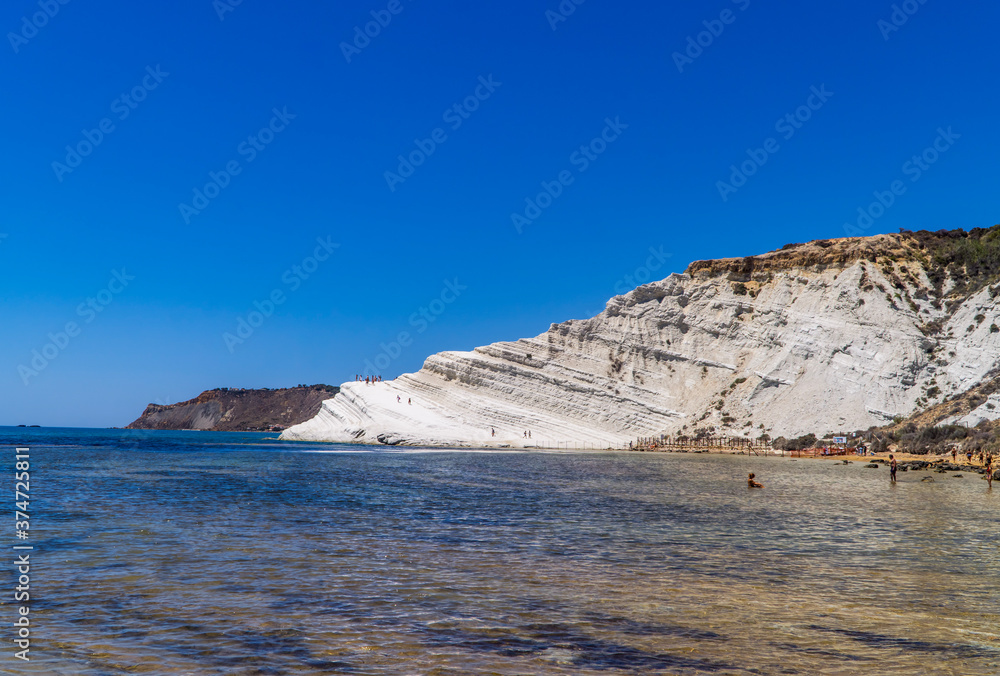 Limestone white cliffs with beach and swimmers at the Scala dei Turchi (Stair of the Turks) near Realmonte, Sicily, Italy