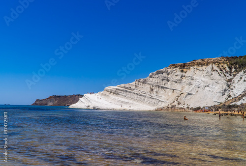 Limestone white cliffs with beach and swimmers at the Scala dei Turchi (Stair of the Turks) near Realmonte, Sicily, Italy