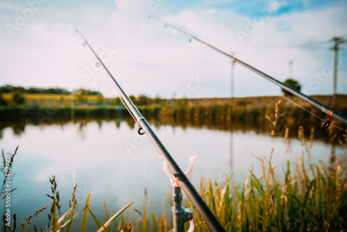 Fisherman`s fishing rod with inertia-free coil in summer on shore of pond. Narrow focus. © GetFocusArt