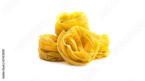 Uncooked fettuccine nest pasta on white background. High quality photo