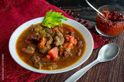 Moroccan Beef Stew with Harissa: A bowl of spicy beef and vegetable stew served with harissa sauce on the side