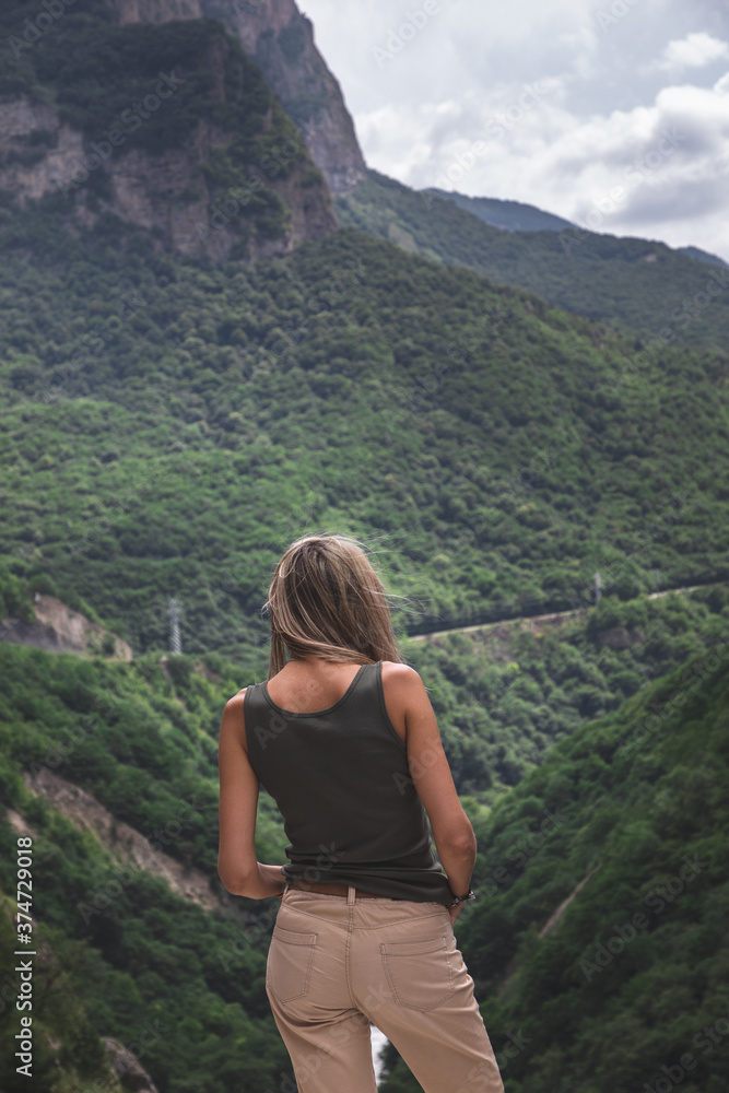 Blonde girl looks at a beautiful gorge in kabardino-balkaria republic.