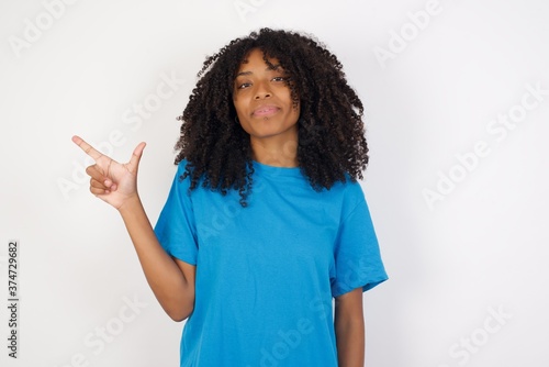 Young african woman with curly hair wearing casual blue shirt pointing up with fingers number eight in Chinese sign language BÄ.