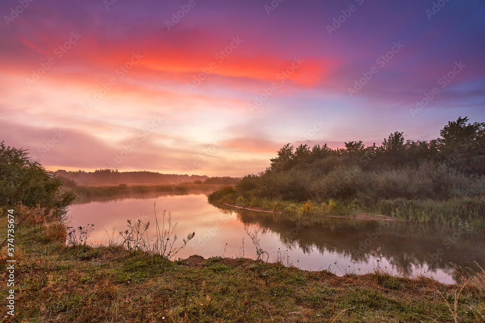 River misty autumn sunrise. Colorful dawn. Cloudy sunrise. Dusk fall colors