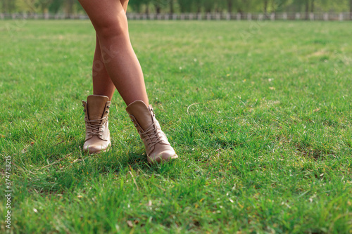 womans feet in the grass. walking on a field