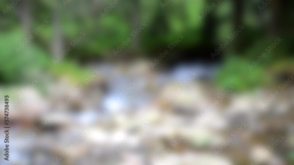 Blurred background. Mountain stream in the forest with big stones Blurred background. Mountain stream in the forest with big stones