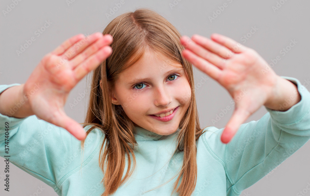 Φωτογραφία Close-up Young woman face and eye care and she making frame with hands isolated over gray background