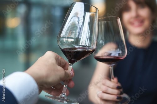 Happy couple drinking red wine. Selective focus on wine glass.