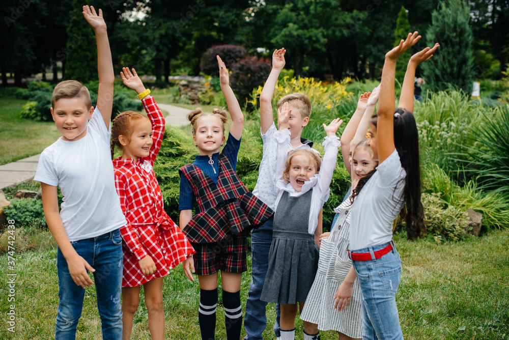 Fototapeta premium A group of children run around, have fun and play as a larger team in the summer in the Park. Happy childhood